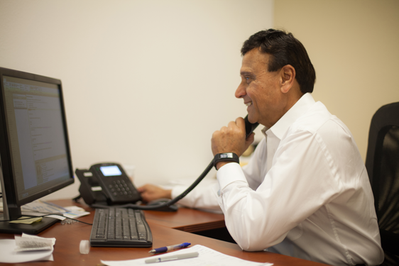 Photo: Sayed Ali, President & CEO of Interpreters Unlimited at his desk on the phone